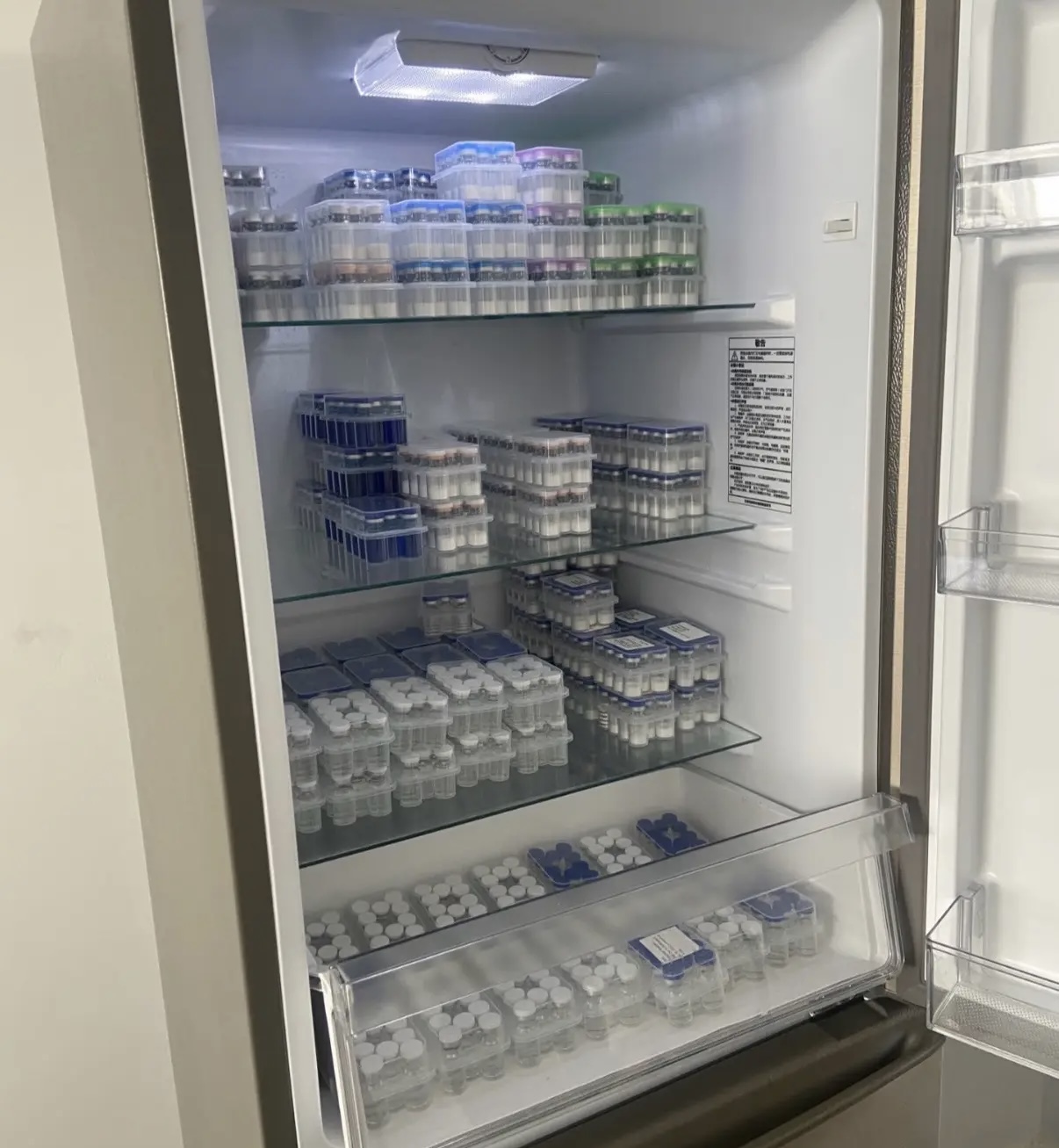 Packaged vials arranged on refrigerator shelves